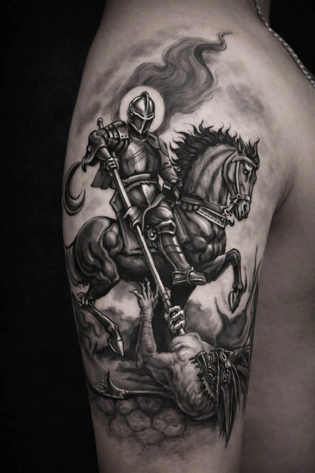 Black and grey realism tattoo of a knight slaying a dragon