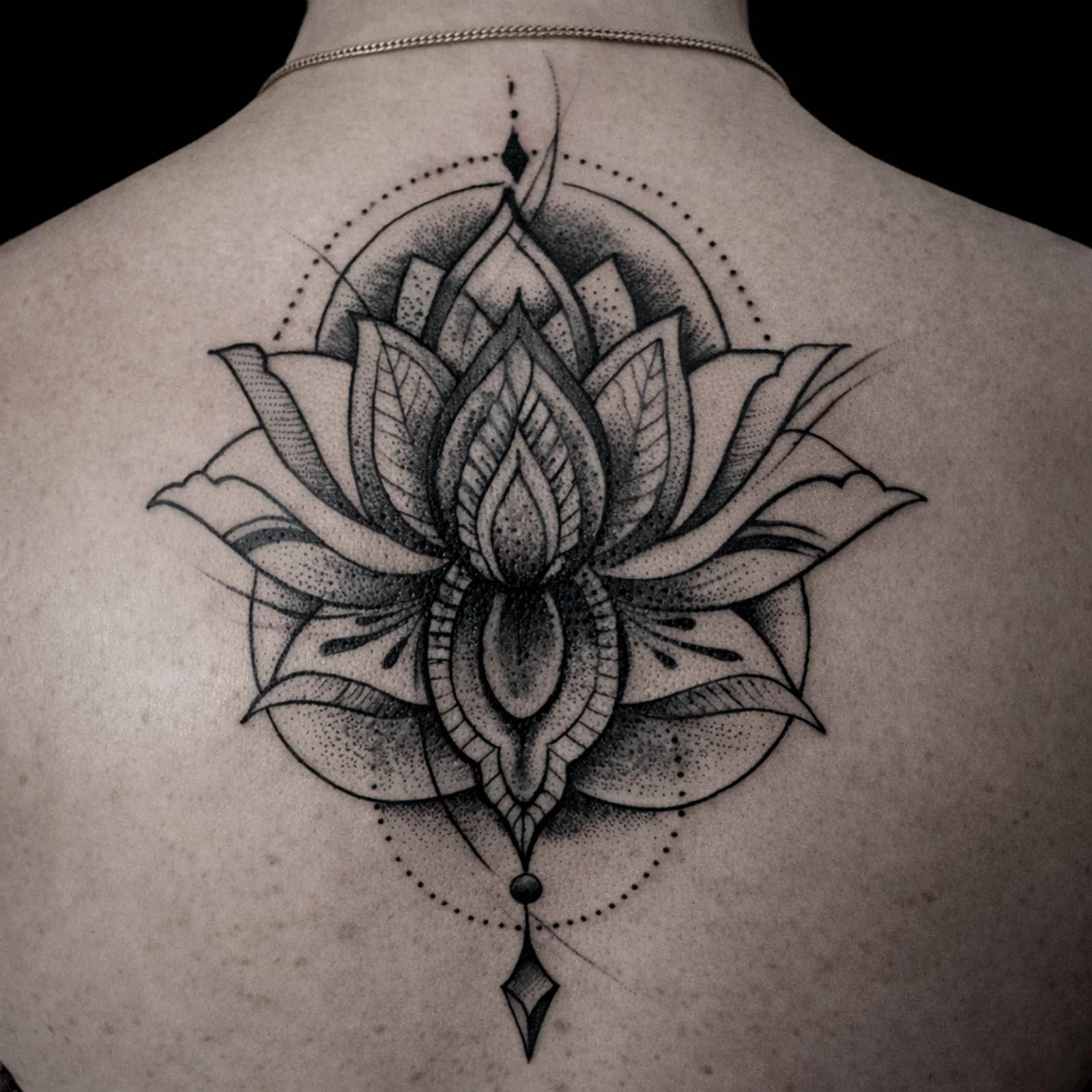Black and grey dotwork lotus mandala tattoo on back